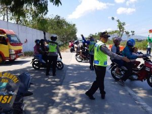 Polisi mengatur keluar masuk kendaraan wisatawan di jalur Pantura Rembang.