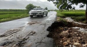 Sebuah mobil melintas di Jalan Rembang – Sumber yang rawan amblas akibat tergerus hujan. 