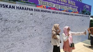 Warga berswafoto di depan banner harapan untuk Rembang. (Foto atas) Group musik Guyon Waton menggoyang Alun-Alun Rembang, Minggu (25/09).