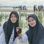 Dua santriwati menunjukkan bibit bakau yang akan ditanam di pinggir pantai utara Desa Pasar Banggi, Rembang, baru-baru ini.