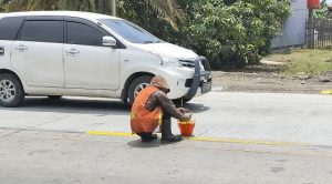 Pekerja membuat garis marka di jalan beton Desa Raci Kecamatan Batangan. (Foto atas) Lalu lintas di perbatasan Rembang – Pati terpantau lancar.