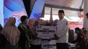 Bupati Rembang, Abdul Hafidz saat memberikan bantuan kepada lansia.