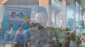 Joko Supriyadi, juru bicara pasangan Harmonis, dengan latar belakang baliho Harno – Hanies.