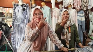 Dua pedagang di Pasar Rembang berpose huruf V dan U, simbol dari Vivit dan Umam.