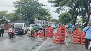 Petugas Damkar BPBD Rembang menyemprot pecahan botol dari lokasi kecelakaan di jalur Pantura, depan RSI Arafah Rembang, Senin siang (09/06).