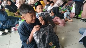 Anak-anak menunjukkan tas dari Baznas Rembang, ketika kegiatan Gebyar Muharram di Gedung Haji, Minggu (06/07).
