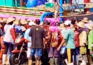 Masyarakat mengerubungi kendaraan yang mengevakuasi korban, saat membongkar ikan di Pelabuhan Tasikagung Rembang, Sabtu (11/10).