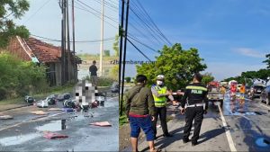 Korban tergeletak dan galon berisi Pertamax berserakan. Polisi mendatangkan Damkar untuk membersihkan tumpahan BBM, Sabtu pagi (06/12).