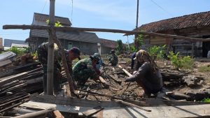 Pembersihan puing-puing kayu rumah, saat penataan rumah tidak layak huni, dalam program TMMD di Desa Ngajaran Kecamatan Sale.